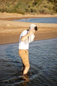 Rear view of woman standing in lake