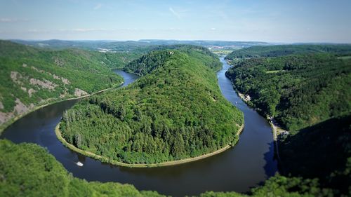 High angle view of river amidst green landscape against sky