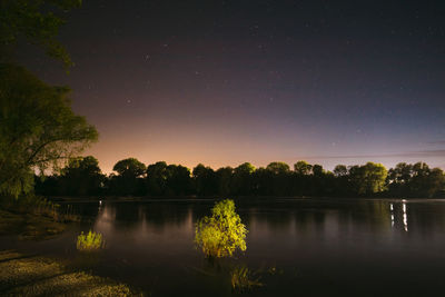 Scenic view of lake against sky at night