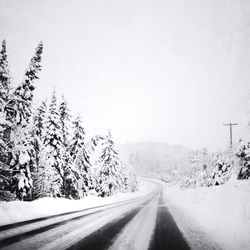 Road passing through snow covered landscape