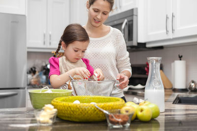 Happy young woman eating food at home