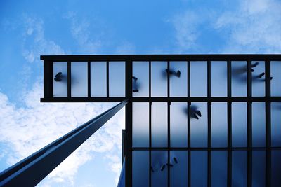 Low angle view of glass ceiling against sky