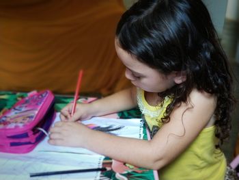 Side view of girl doing homework at home