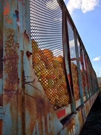 Low angle view of rusty metal against sky