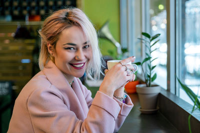 Young woman is drinking coffee in a cafe.