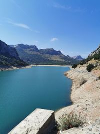 Scenic view of lake and mountains against blue sky