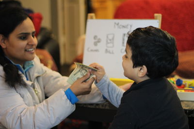 Mother teaching home finance to child at home