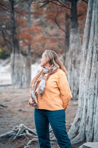 Full length of woman standing on tree trunk