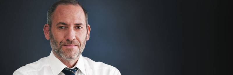 Portrait of man against black background