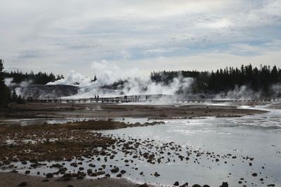 Steam emitting from geyser at yellowstone national park against sky