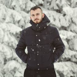 Portrait of young man standing outdoors in the snow