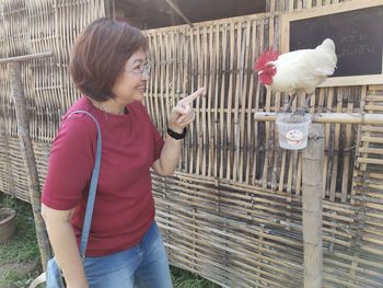 Full length of woman standing by birds