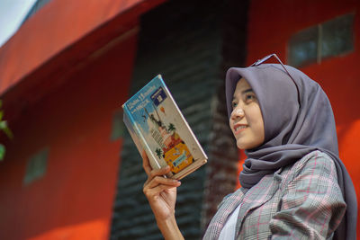 Portrait of young woman holding paper currency