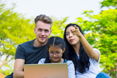 Happy family using laptop at park