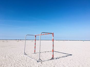 Lifeguard hut on beach against blue sky