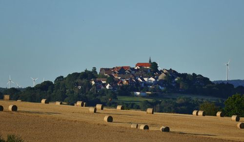 Hay bales on field against clear sky