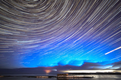 Illuminated sea against sky at night