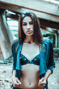 Portrait of beautiful young woman standing against wall