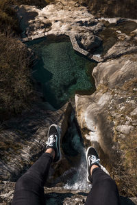 Low section of woman on rock against sea