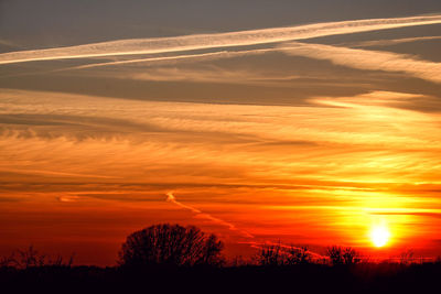 Scenic view of silhouette landscape against orange sky