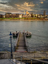 High angle view of pier over river by buildings against sky