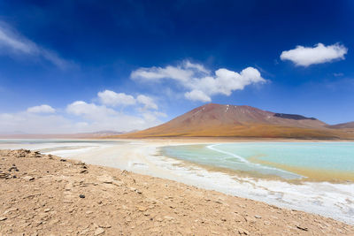 Scenic view of beach against blue sky