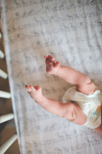 Low section of baby girl in crib