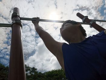 Low angle view of man looking at camera against sky