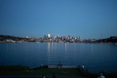 Scenic view of sea by buildings against clear sky