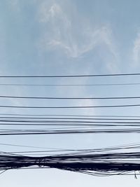 Low angle view of power lines against sky