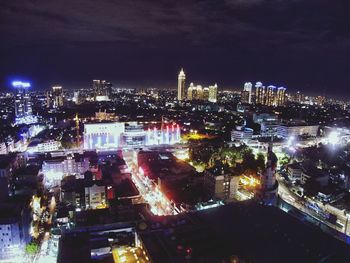 Illuminated cityscape against sky at night