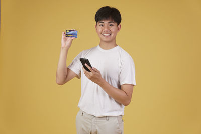 Portrait of smiling young man using mobile phone