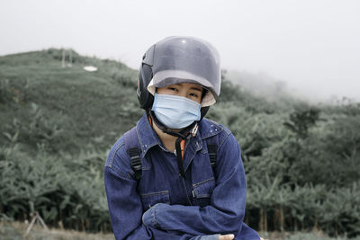 Portrait of man standing on field against sky