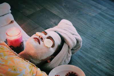 High angle view of woman with face mask lying at spa