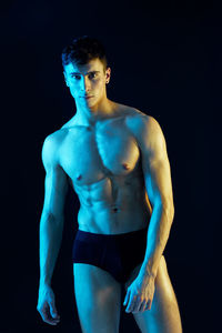 Portrait of shirtless man against black background