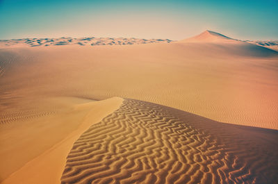 Sand dune in desert against sky