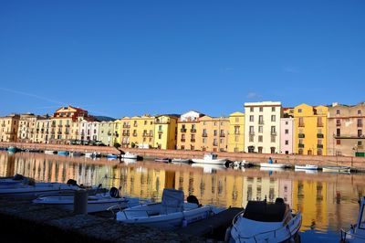 Buildings in city against clear blue sky