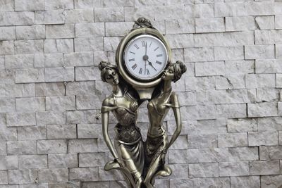 Close-up of clock on brick wall