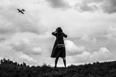 Low angle view of women standing against sky 