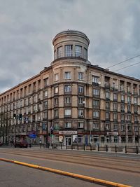 Building by road against sky in city