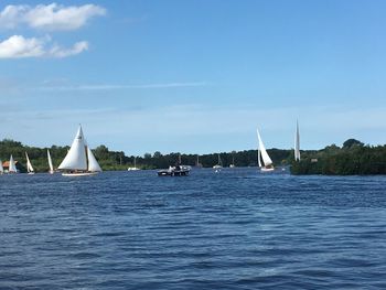 Sailboats sailing on sea against sky