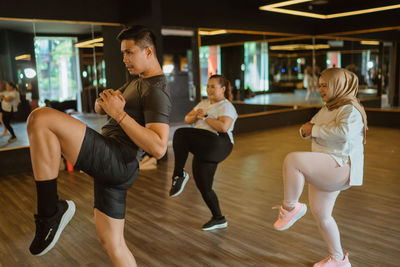 Side view of friends exercising in gym