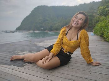 Portrait of smiling young woman sitting outdoors