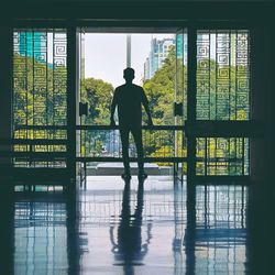 Rear view of silhouette man standing in building