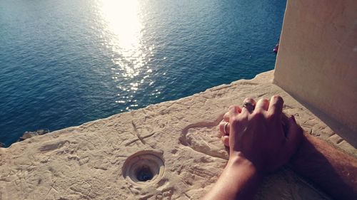 High angle view of couple holding hands on stone material