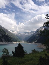 Scenic view of mountains and lake against cloudy sky