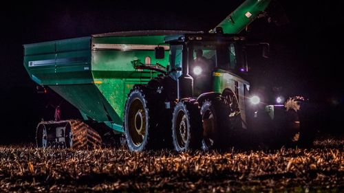 Cars on field against sky at night
