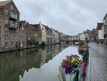 Canal amidst buildings in town against sky