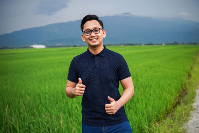 Portrait of young man standing on field