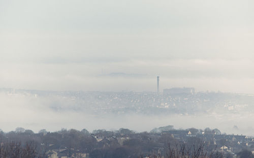 City against sky during foggy weather